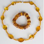 A single row bracelet of twelve disc shaped vari-coloured mottled opaque honey coloured amber and