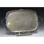 A George V silver two-handled tray with cast gadrooned and scallop shell rim, flanked by a pair of