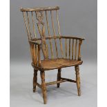 An early 20th century ash primitive Windsor armchair, the pierced back above a panel seat, height