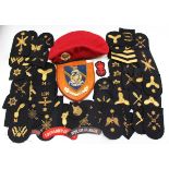 A collection of naval-related cloth and gilt braid badges, a military police red beret, a collection