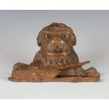 A late 19th/early 20th century Swiss Black Forest carved softwood novelty inkwell, modelled as a dog