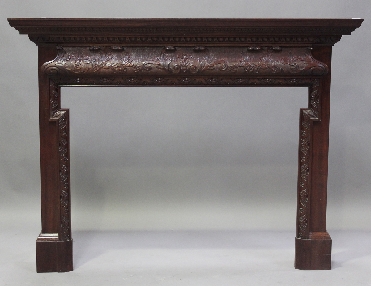 A modern reproduction mahogany fire surround with finely carved decoration, height 120cm, width