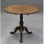 An early Victorian oak tip-top wine table, raised on tripod legs, height 68cm, diameter 78cm.Buyer’s