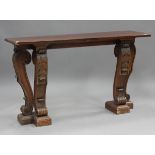 A 20th century Italianate stained pine console table, raised on four finely carved acanthus leaf