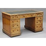 A late Victorian pale oak twin pedestal desk, the top inset with gilt-tooled green leather above