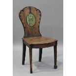 An 18th century mahogany hall chair, the shaped back painted with an armorial crest, with overall