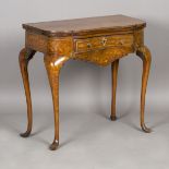 An 18th century Dutch walnut floral marquetry fold-over games table, the hinged top enclosing an
