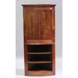 A George III and later figured mahogany corner cabinet-on-stand, the crossbanded doors enclosing