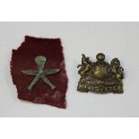 A Manchester Regiment bronze finish cap badge and a post-Second World War Airborne Gurkha regimental