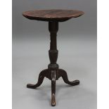 A 19th century provincial pine wine table, the circular top on a brown painted tripod base, height