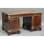 A 20th century French Empire style figured mahogany twin pedestal desk with overall brass mounts,