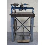 A blue enamelled cast iron and steel treadle-powered watchmaker's lathe and workbench, length of