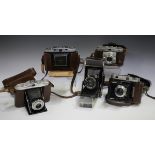 A collection of twenty-five folding cameras, including a Voigtländer Vito II A, an Ikonta M and an