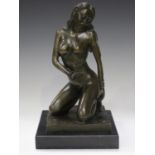 A modern green patinated cast bronze figure of a crouching nude female, raised on a hardstone