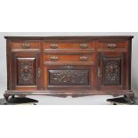 A late Victorian walnut sideboard with carved decoration, fitted with drawers and cupboards,
