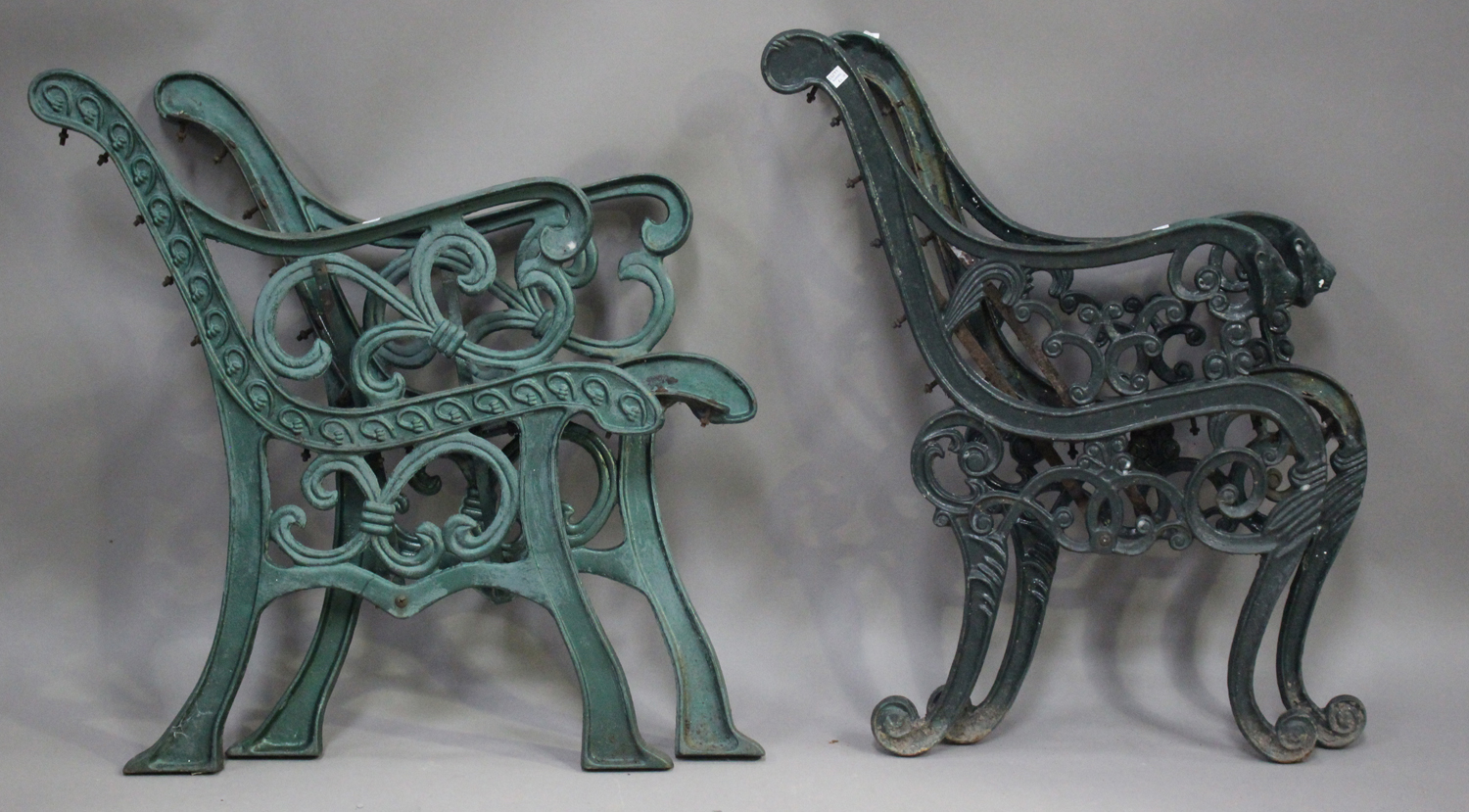 A pair of early 20th century green painted cast iron bench ends of scroll form, height 83cm, depth