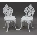A pair of late Victorian white painted cast iron garden chairs of foliate scroll form, height