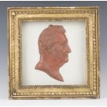 A Regency relief portrait plaque of a gentleman's head in profile, probably red stained wax, mounted