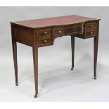 An Edwardian mahogany and boxwood inlaid writing table, fitted with five drawers, on square tapering