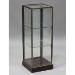 A mid-20th century brass framed display case with lockable hinged door, two glass shelves and