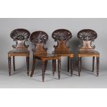 An impressive set of four Regency mahogany shell back hall chairs, in the manner of Gillows of