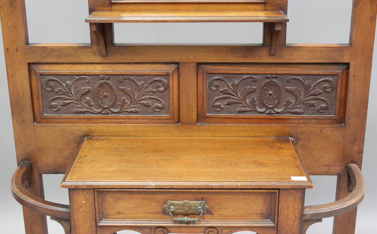 A late Victorian oak hallstand with carved foliate decoration, fitted with a drawer, on turned - Image 5 of 6