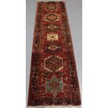 A Heriz runner, North-west Persia, mid-20th century, the red field with a column of hooked
