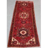 A Heriz runner, North-west Persia, mid-20th century, the claret field with five flowerhead