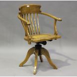 A late 20th century Chinese elm revolving desk chair with woven rattan seat, on downswept legs,