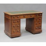 A late Victorian walnut twin pedestal desk, fitted with an arrangement of drawers, on plinth