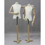 A pair of modern beech and calico-covered tailor's dummies with fully articulated arms and hands, on