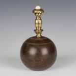 A lignum vitae doorstop, formed from a bowling bowl with brass handle, height 23cm.Buyer’s Premium