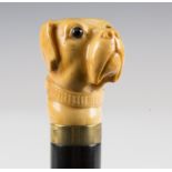 A 19th century ebonized walking cane, the ivory handle finely carved as a dog's head with inset