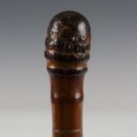 A late 19th century Japanese bamboo walking cane, carved in overall relief with birds and foliage,