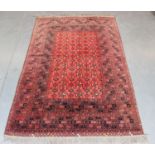 An Afghan carpet, mid/late 20th century, the red field with a floral lattice, within a wide