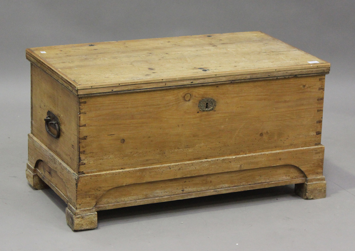 A late 19th century pine trunk, the hinged lid revealing a candlebox, height 50cm, width 96cm, depth