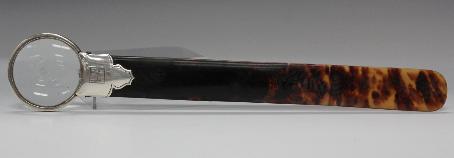 An early 20th century tortoiseshell and silver mounted page turner with magnifying lens terminal,