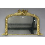 A late Victorian gilt painted overmantel mirror, the arched frame with putto and fern surmount,