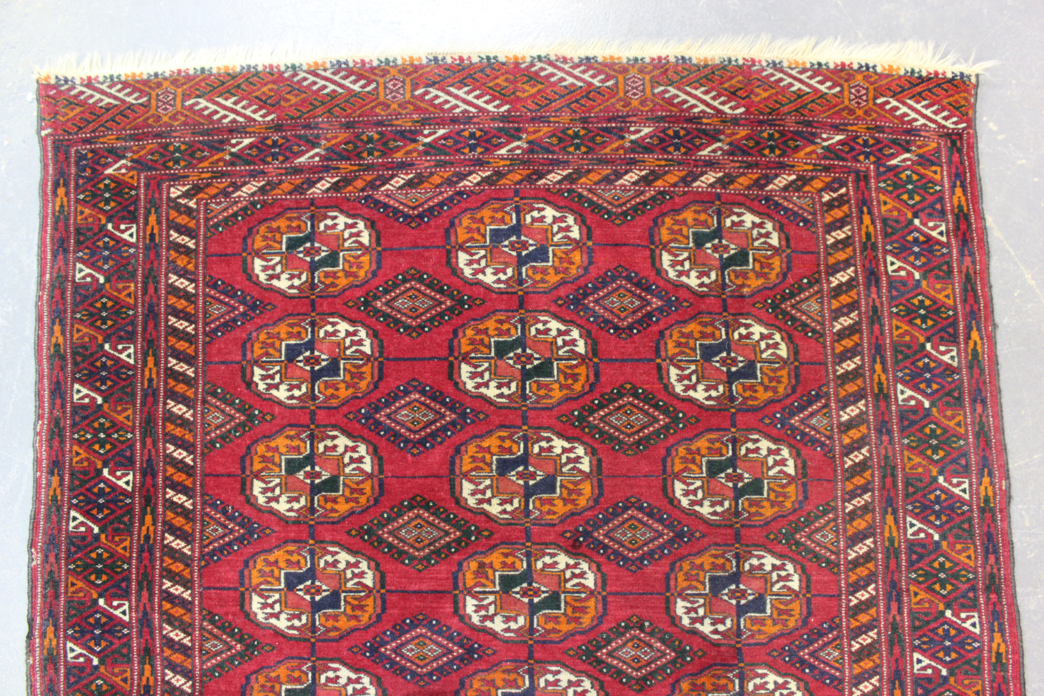 A Tekke rug, West Turkestan, mid-20th century, the claret field with three columns of guls, within a - Image 2 of 4