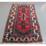 A Turkish rug, mid/late 20th century, the red field with three cruciform medallions, within a