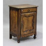 An early 20th century French oak narrow side cabinet, fitted with a drawer and a cupboard, on scroll