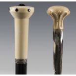 An early 20th century ebonized walking cane, the finely turned ivory handle inset with red gems