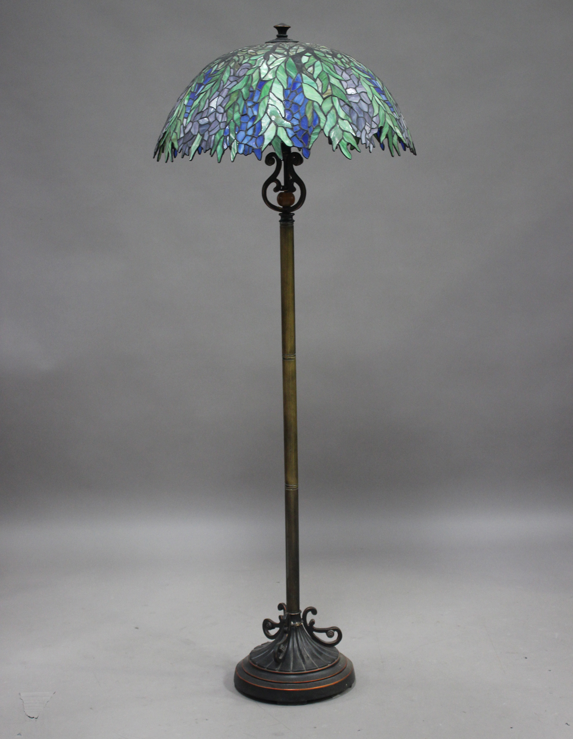 A modern anodized metal lamp standard, fitted with a large Tiffany style stained and leaded glass