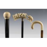 An early 20th century ebonized walking cane, the ivory handle carved with an elephant, length