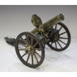 A late 20th century cast metal and wooden desk model of Gatling gun, mounted on a wheeled