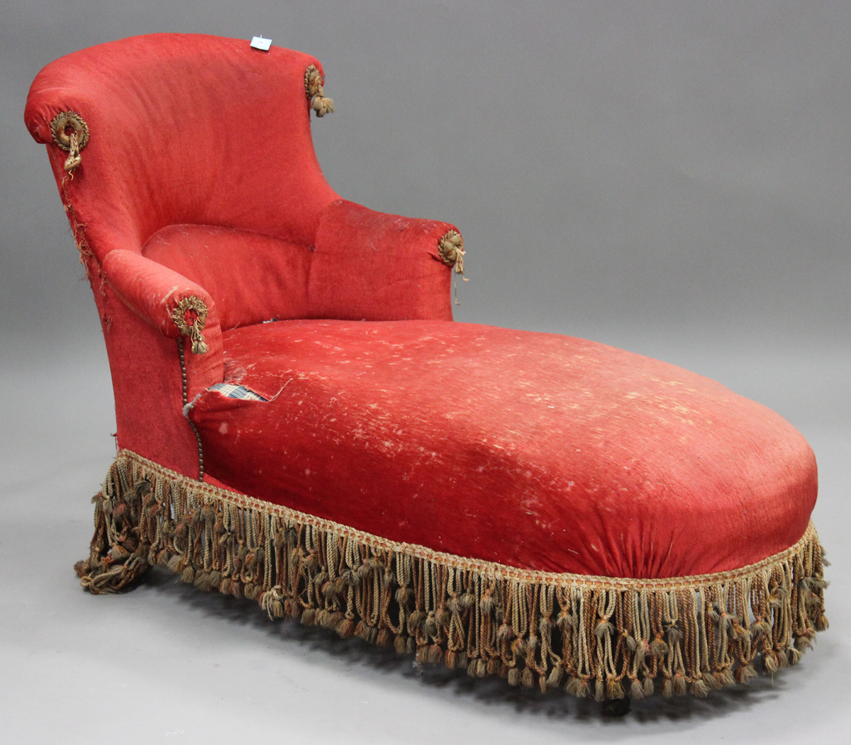 A late Victorian tub back daybed, upholstered in crimson velvet, raised on shaped legs, height 95cm,