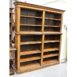A Victorian oak open library bookcase, the moulded pediment above adjustable shelves, on a plinth