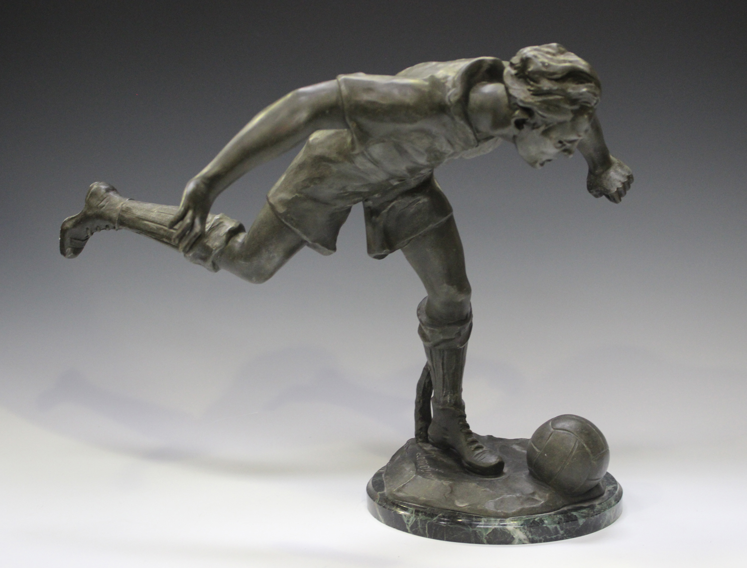 Lemoyne - a French patinated spelter figure of a footballer about to strike a ball, the base bearing