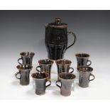 A Jeremy Leach Lowerdown pottery coffee pot and eight mugs, 1970s, each covered in a tenmoku