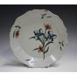 A Delft plate, 18th century, painted in blue, green and red with a floral spray, diameter 22.5cm (